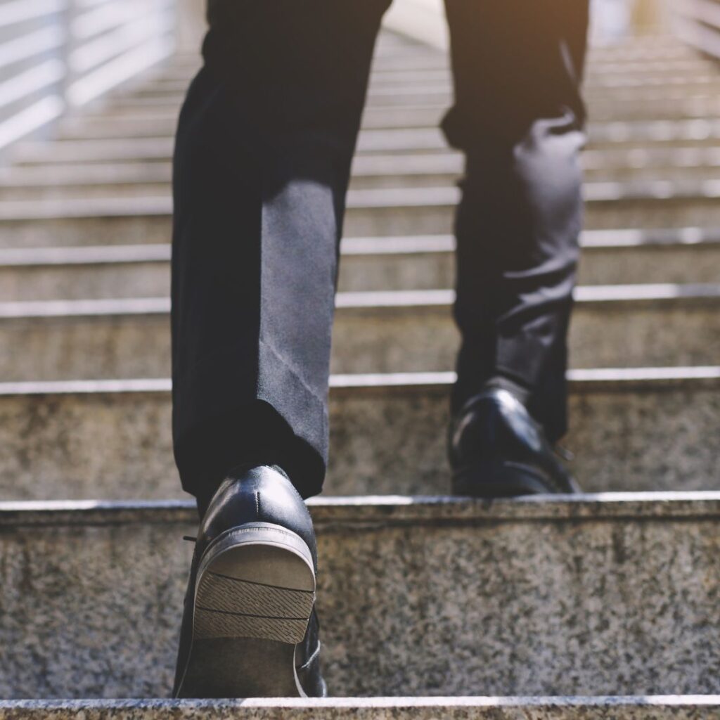 A leader stepping on stairs